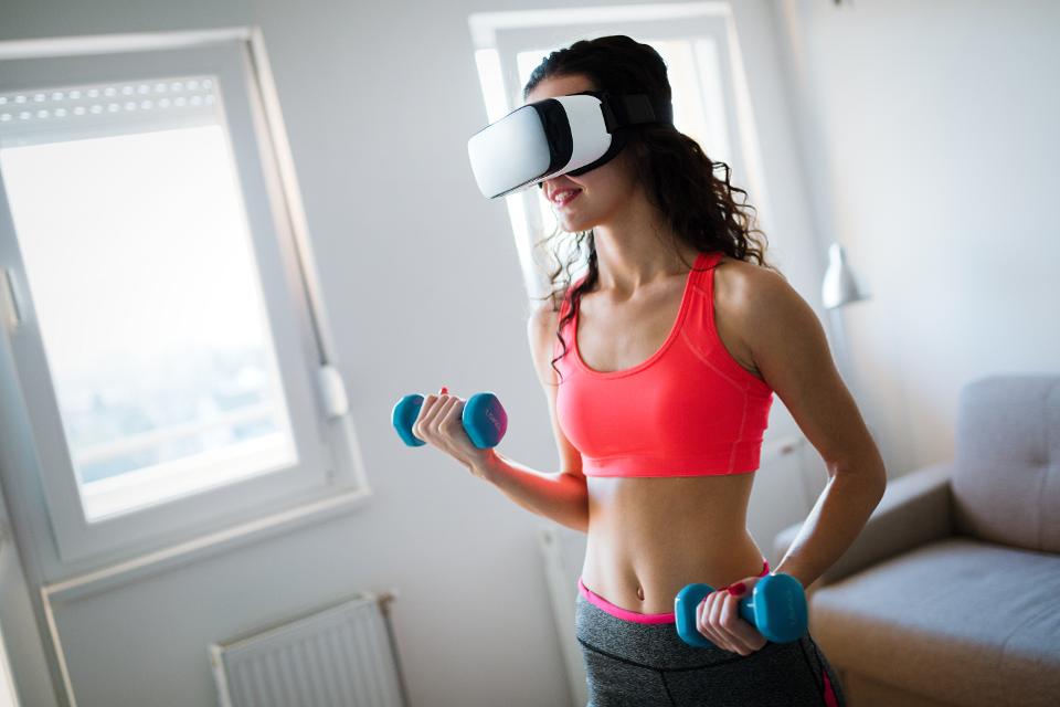 Young woman doing exercises wearing vr goggles
